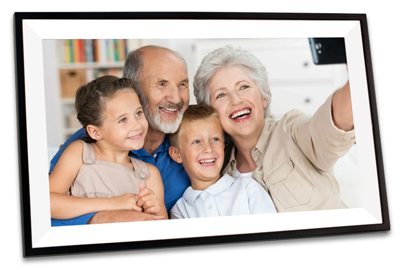 A framed photo of a smiling family consisting of two children and their grandparents taking a selfie together