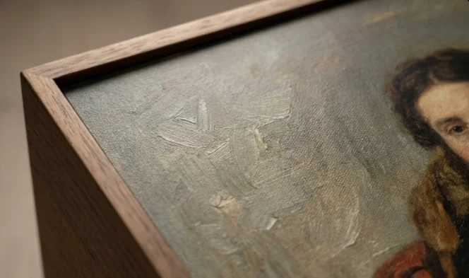 Close-up of a wooden digital art frame displaying realistic canvas texture and brushstrokes.